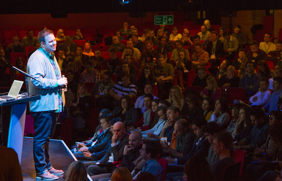 A photograph of Brett Harned on stage.