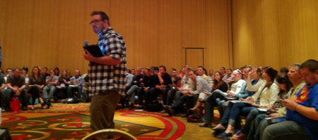 A photograph of Brett Harned presenting his talk at the 2011 SXSW event surrounded by a circular row of audience members