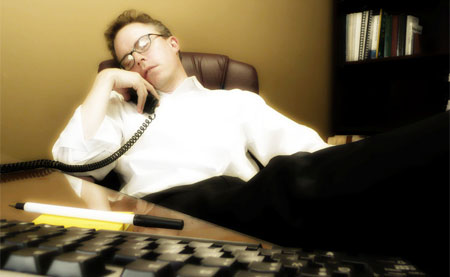 An office worker asleep while on the phone