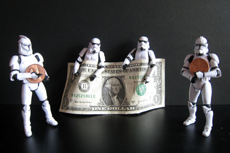 Stormtrooper toy figures holding U.S. dollar notes and coins