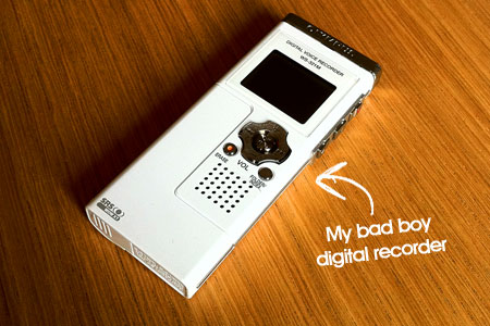 A picture of a white digital voice recorder on a wooden surface